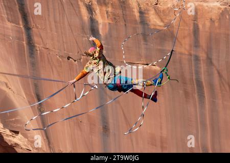 Un Highliner maschile perde l'equilibrio e frulla, o cade fuori dall'Highline in un festival Highline nello Utah. La sua imbracatura protettiva e il guinzaglio lo impediscono Foto Stock