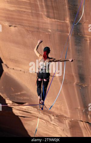 Una giovane donna che cammina su una linea principale al GGBY World Highline Festival nel Mineral Canyon vicino a Moab, Utah. Foto Stock