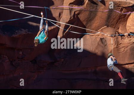 Un Highliner maschile perde l'equilibrio e frulla, o cade fuori dall'Highline in un festival Highline nello Utah. La sua imbracatura protettiva e il guinzaglio lo impediscono Foto Stock