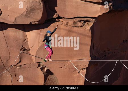 Una giovane donna che cammina su una linea principale al GGBY World Highline Festival nel Mineral Canyon vicino a Moab, Utah. Foto Stock