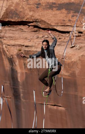 Una giovane donna che cammina su una linea principale al GGBY World Highline Festival nel Mineral Canyon vicino a Moab, Utah. Foto Stock