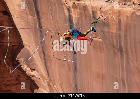 Un Highliner maschile perde l'equilibrio e frulla, o cade fuori dall'Highline in un festival Highline nello Utah. La sua imbracatura protettiva e il guinzaglio lo impediscono Foto Stock