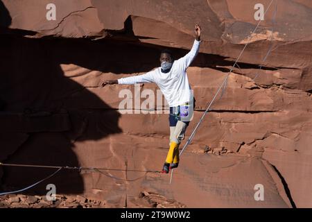 Un giovane nero che cammina su una linea principale al GGBY World Highline Festival nel Mineral Canyon vicino a Moab, Utah. Foto Stock