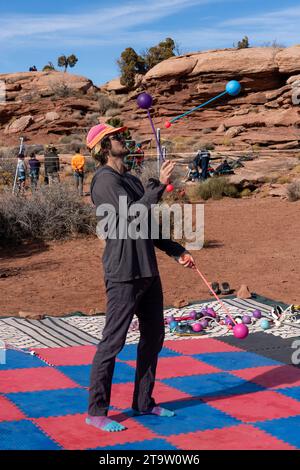 Un partecipante al GGBY Highlining Festival pratica la sua giocoleria senza camminare in prima linea. Moab, Utah. Foto Stock