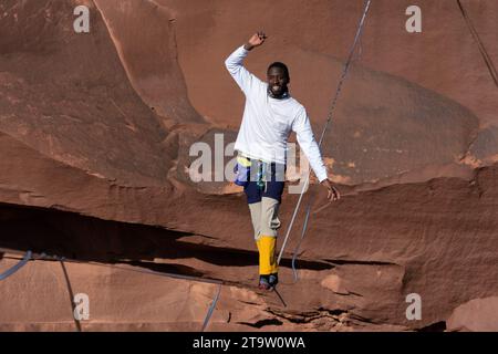 Un giovane nero che cammina su una linea principale al GGBY World Highline Festival nel Mineral Canyon vicino a Moab, Utah. Foto Stock