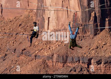 Un Highliner maschile perde l'equilibrio e frulla, o cade fuori dall'Highline in un festival Highline nello Utah. La sua imbracatura protettiva e il guinzaglio lo impediscono Foto Stock