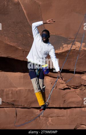 Un giovane nero che cammina su un bendato al GGBY World Highline Festival nel Mineral Canyon vicino a Moab, Utah. Foto Stock