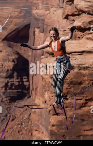 Una giovane donna che cammina su una linea principale al GGBY World Highline Festival nel Mineral Canyon vicino a Moab, Utah. Foto Stock