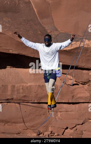 Un giovane nero che cammina su un bendato al GGBY World Highline Festival nel Mineral Canyon vicino a Moab, Utah. Foto Stock