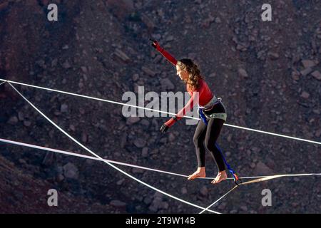 Una giovane donna che cammina su una linea principale al GGBY World Highline Festival nel Mineral Canyon vicino a Moab, Utah. Foto Stock