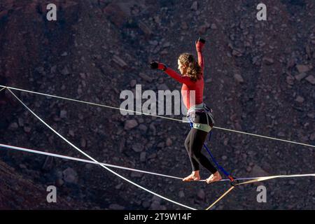 Una giovane donna che cammina su una linea principale al GGBY World Highline Festival nel Mineral Canyon vicino a Moab, Utah. Foto Stock