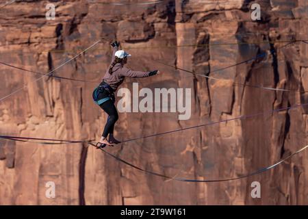 Una giovane donna che cammina su una linea principale al GGBY World Highline Festival nel Mineral Canyon vicino a Moab, Utah. Foto Stock