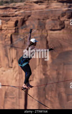 Una giovane donna che cammina su una linea principale al GGBY World Highline Festival nel Mineral Canyon vicino a Moab, Utah. Foto Stock