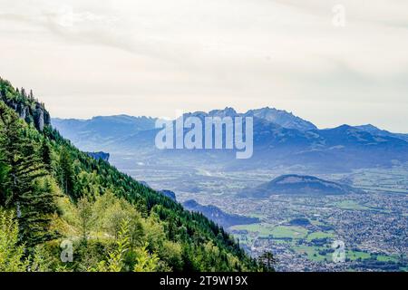 Il paesaggio si sviluppa in un vasto panorama, con valli sottostanti e un cielo limpido e vasto sopra. Foto Stock