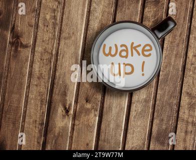 vista panoramica su una tazza di latte su un tavolo di legno con sveglia a parole, concetto di colazione Foto Stock