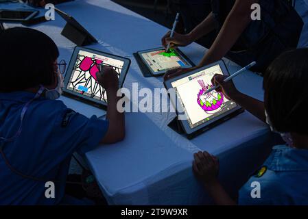 Bangkok, Thailandia. 27 novembre 2023. I bambini creano il proprio Krathong virtuale prima di rilasciarlo come luci illuminate nel canale durante il Loy Krathong Festival al canale Khlong ONG Ang a Bangkok. Il Virtual Loy Krathong con tecnologia di mappatura della proiezione si è svolto presso il canale Khong ONG Ang a Bangkok. Questa idea mira a ridurre gli sprechi nell'annuale festival Loy Krathong. (Foto di Peerapon Boonyakiat/SOPA Images/Sipa USA) credito: SIPA USA/Alamy Live News Foto Stock