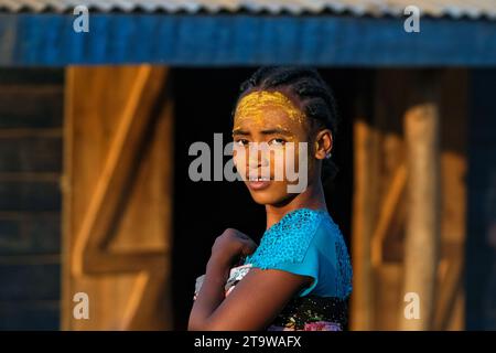 Ragazza malgascia con maschera di protezione solare realizzata con radice Musiro a Begidro vicino ad Ankiliroroka, Belo sur Tsiribihina, Menabe, Highlands centrali, Madagascar Foto Stock