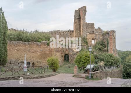 Paesaggio urbano con le rovine della fortezza di Rocca Aldobrandesca nel villaggio storico, scattato alla luce luminosa dell'inizio dell'autunno a Sovana, Toscana, Italia Foto Stock