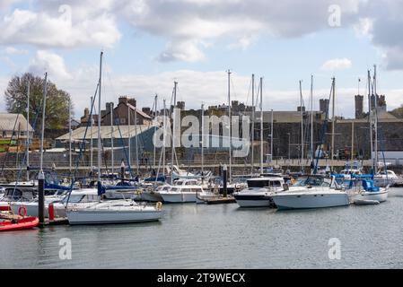Piccole barche ormeggiate nel porto di Caernarfon, sulla costa del Galles del Nord. Foto Stock
