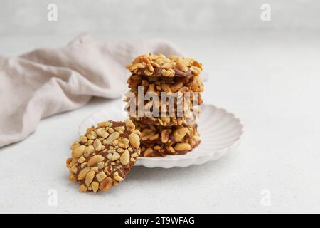 Un mucchio di biscotti tradizionali alle arachidi portoghesi noti come Bolachas de Amendoim sul piatto bianco Foto Stock