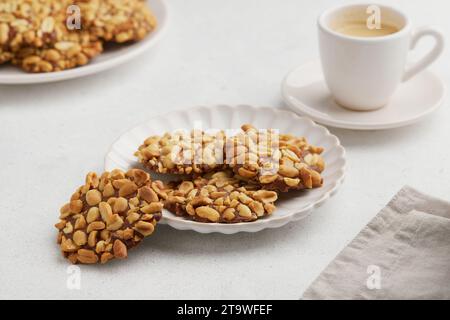 Un mucchio di biscotti tradizionali alle arachidi portoghesi noti come Bolachas de Amendoim sul piatto bianco Foto Stock