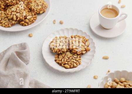 Un mucchio di biscotti tradizionali alle arachidi portoghesi noti come Bolachas de Amendoim sul piatto bianco Foto Stock