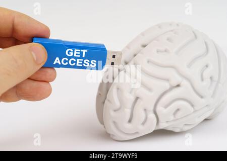 Un uomo inserisce una chiavetta nel suo cervello con l'iscrizione - ottenere l'accesso. Concetto aziendale e tecnologico. Foto Stock