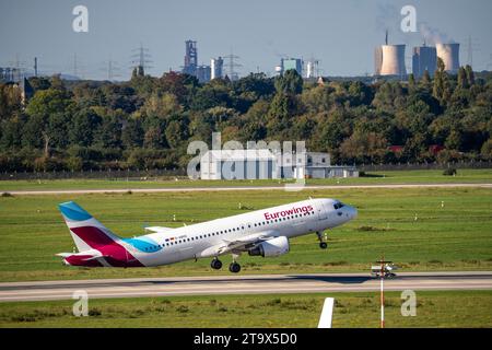 Aeroporto di Düsseldorf, aeromobili che decollano dalla pista principale, Eurowings Airbus A320-200, D-ABHG, con le acciaierie HKM di Duisburg sullo sfondo Foto Stock