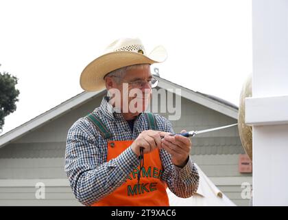 Half Moon Bay, CA - 14 ottobre 2023: Farmer Mike Carving Pumpkins al 50° Art and Pumpkin Festival nel World Pumpkin Capitol di Half Moon B. Foto Stock