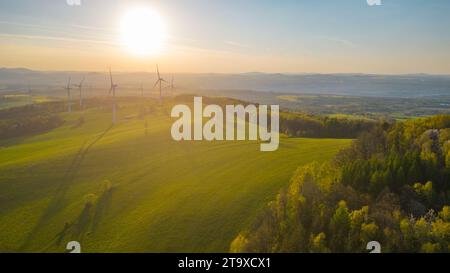 Centrale eolica al tramonto. Tema energia pulita e sostenibile. Vista aerea con droni. Foto Stock