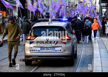 Marsiglia, Francia. 25 novembre 2023. I manifestanti curdi marciano con bandiere viola, seguiti da un'auto della polizia nazionale durante la marcia dimostrativa a Marsiglia. Manifestazione contro la violenza contro le donne curde a Marsiglia, in Francia. Credito: SOPA Images Limited/Alamy Live News Foto Stock