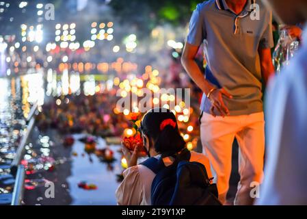 Bangkok, Thailandia. 27 novembre 2023. Una donna dice una preghiera prima di inviare il suo Krathong a galla al Parco Benjasiri, il popolo di Bangkok si riunisce al Parco Benjasiri di Bangkok per celebrare il festival tailandese Loy Krathong che si svolge il 12 ° mese sul calendario lunare tailandese la sera della luna piena. La gente si riunisce al Parco Benjasiri di Bangkok per celebrare il festival tailandese Loy Krathong, che si svolge il 12° mese sul calendario lunare tailandese la sera della luna piena. Credito: SOPA Images Limited/Alamy Live News Foto Stock