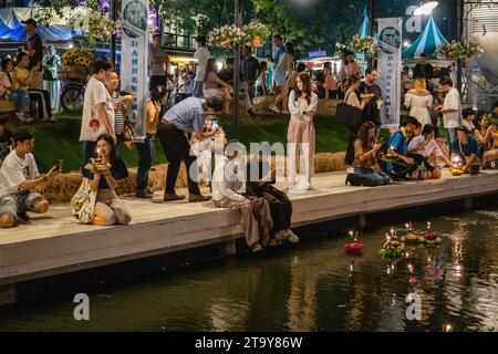 Bangkok, Thailandia. 27 novembre 2023. Tailandesi e stranieri sono visti con il loro krathong, sulla riva del lago, durante il magico Loy Krathong Festival, al Jodd Fairs Dan Neramit, a Bangkok. Loy Krathong 'per galleggiare rituale vaso o lampada' è un festival thailandese celebrato ogni anno in tutta la Thailandia†e nei paesi vicini, dove la notte della luna piena, i Krathong, decorati con foglie di banana riccamente piegate, tre bastoncini di incenso, e una candela, vengono lanciate dai thailandesi, su un fiume, un canale o uno stagno, facendo un desiderio come fanno. Credito: SOPA Images Limited/Alamy Live News Foto Stock