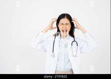 Medico con mal di testa stressato. Infermiere/medico con emicrania sovraccarichi e stressati. Operatore sanitario in camice da laboratorio che indossa stetoscopio Foto Stock