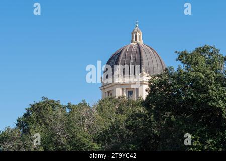 Cupola della chiesa sopra gli alberi verdi alla luce del giorno. Foto Stock