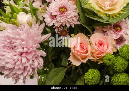 Bouquet di splendidi fiori con rose rosa, fiori di brassica, crisantemo e fiori di freesia come sfondo. Foto Stock