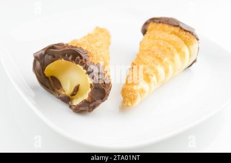 delizioso cannolo siciliano cannellino dolce con pasticceria cioccolato alle nocciole e crema pasticcera, pasta sfoglia italiana su fondo bianco, concetto nutrizionale e dietetico Foto Stock