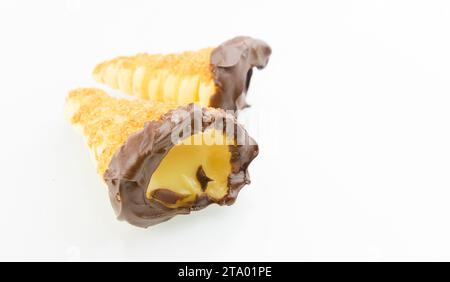 delizioso cannolo siciliano cannellino dolce con pasticceria cioccolato alle nocciole e crema pasticcera, pasta sfoglia italiana su fondo bianco, concetto nutrizionale e dietetico Foto Stock