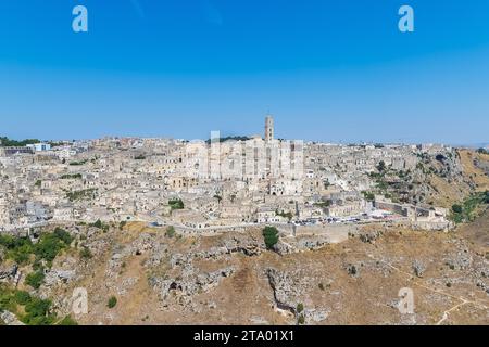 Vista panoramica di pietre tipiche (Sassi di Matera) e la chiesa di Matera UNESCO Capitale Europea della Cultura 2019 sotto il cielo blu. Basilicata, Italia Foto Stock