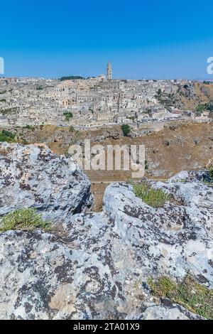 Vista panoramica di pietre tipiche (Sassi di Matera) e la chiesa di Matera UNESCO Capitale Europea della Cultura 2019 sotto il cielo blu. Basilicata, Italia Foto Stock