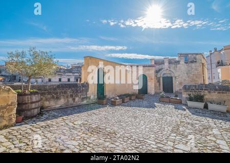 Dettaglio della vista panoramica dei tipici sassi di Matera e della chiesa di Matera sotto il cielo azzurro Foto Stock