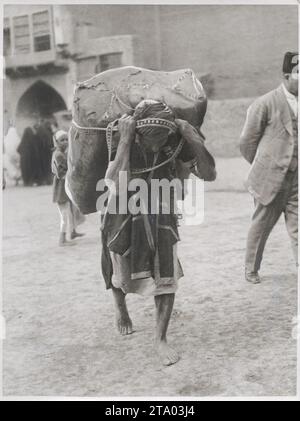 Prima guerra mondiale - operaio nativo a Baghdad in Iraq con un sacco grande Foto Stock
