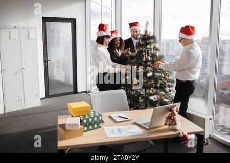 Team di uomini d'affari che festeggiano il nuovo anno in ufficio con finestre panoramiche Foto Stock