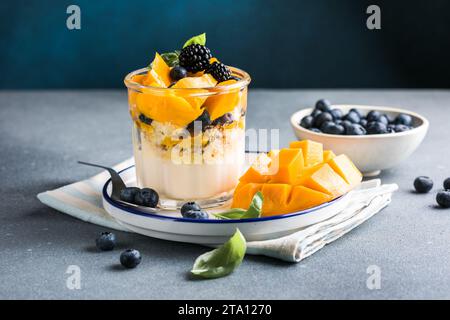Dolce trifle con frutti di bosco e crema su un tavolo di legno. Copia spazio Foto Stock