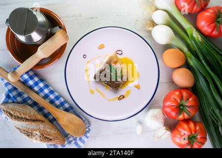 Bacalao al Pil Pil tradizionale tapa dal nord della Spagna. Baccalà cucinato con una deliziosa salsa fatta con olio, baccalà e aglio. Foto Stock