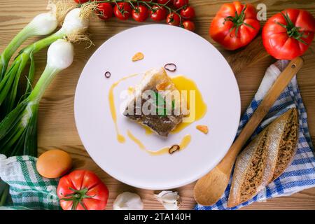 Bacalao al Pil Pil tradizionale tapa dal nord della Spagna. Baccalà cucinato con una deliziosa salsa fatta con olio, baccalà e aglio. Foto Stock