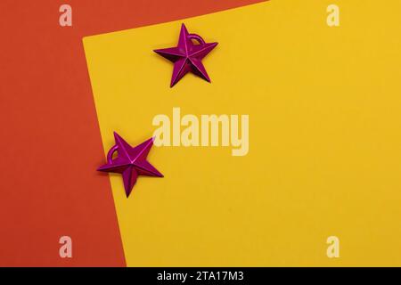 Sfondo natalizio con stelle su sfondo rosso e giallo. Copia spazio. Foto Stock