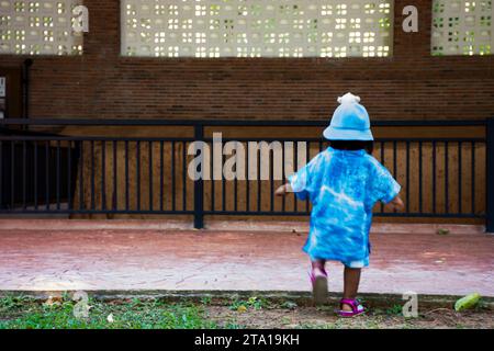 Piccolo bambino tailandese carino bambino bambino e famiglia genitori viaggiano per visitare le antiche rovine del castello di arenaria Muang Sing di Prasat Mueang Sing storico Foto Stock