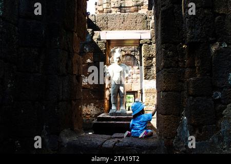 Piccolo bambino tailandese carino bambino bambino e famiglia genitori viaggiano per visitare le antiche rovine del castello di arenaria Muang Sing di Prasat Mueang Sing storico Foto Stock