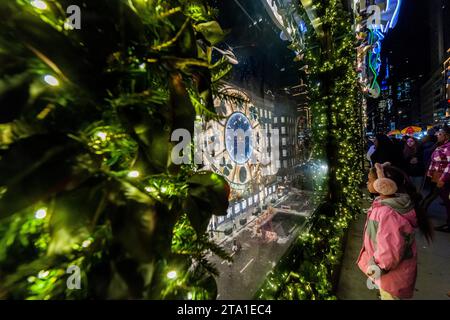 Migliaia di visitatori affollano Saks Fifth Avenue a New York per vedere la loro vetrina natalizia famosa in tutto il mondo e la collaborazione di Saks con Dior per il loro spettacolo di luci, mercoledì 22 novembre 2023 (© Richard B. Levine) Foto Stock